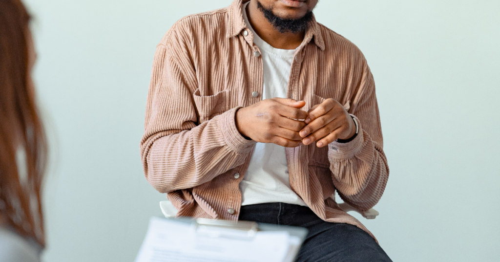 Anxious Man Sitting Holding Hands Talking with Another Person / Professional PTSD Therapy in Chandler, AZ