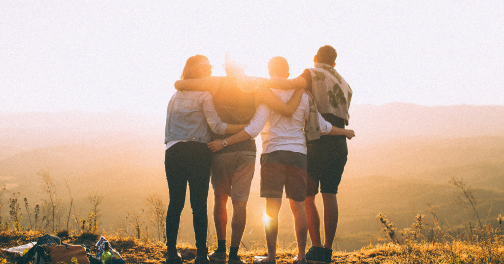 Group of people stand with arms draped over one another looking out over hilly horizon, desert landscape - OCD TREATMENT IN CHANDLER, AZ
